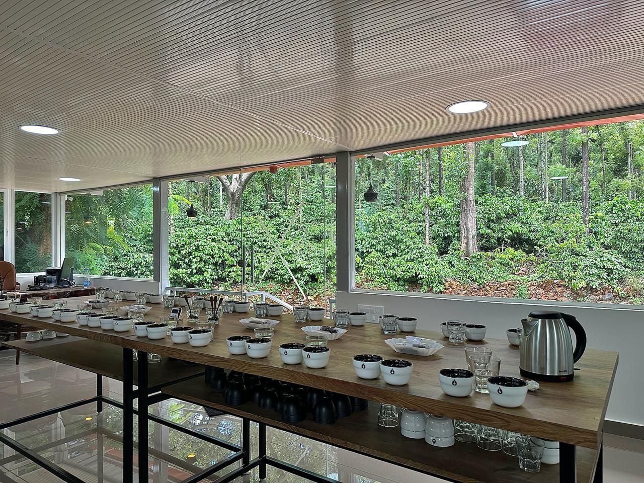 A long cupping table set with bowls and glasses in the estate's cupping room