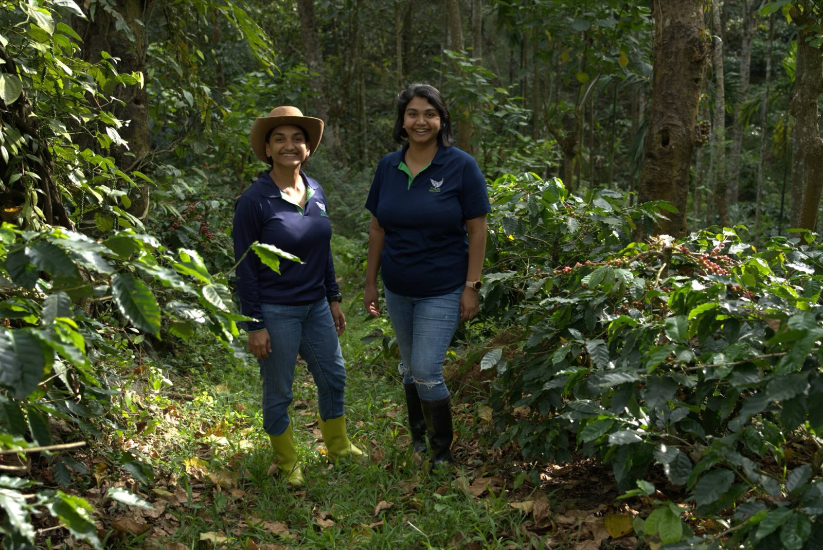 The two sisters who run Harley Estate, smiling among coffee bushes and pepper vines