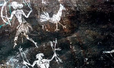 Rock art carvings of a bird alongside human figures